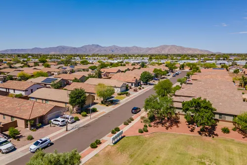 Aerial view of Arizona neighborhood rooftops with mountains behind